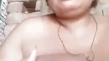 Older Indian widow winks whilst engulfing own large boobs